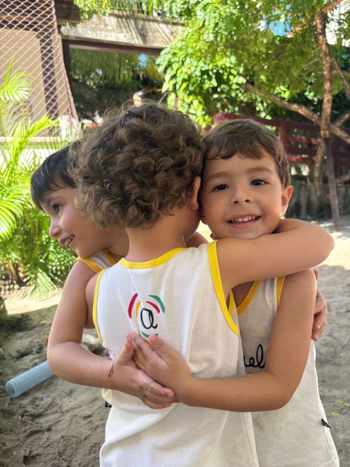 Dois meninos abraçados no quintal do Ateliê Aquarela