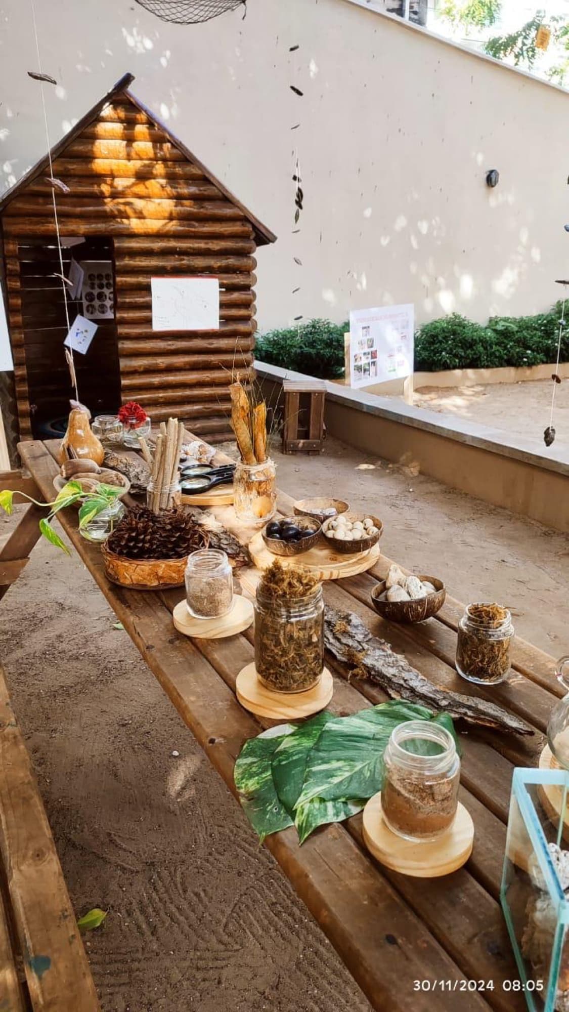 Mesa comprida com elementos naturais em casinha de madeira