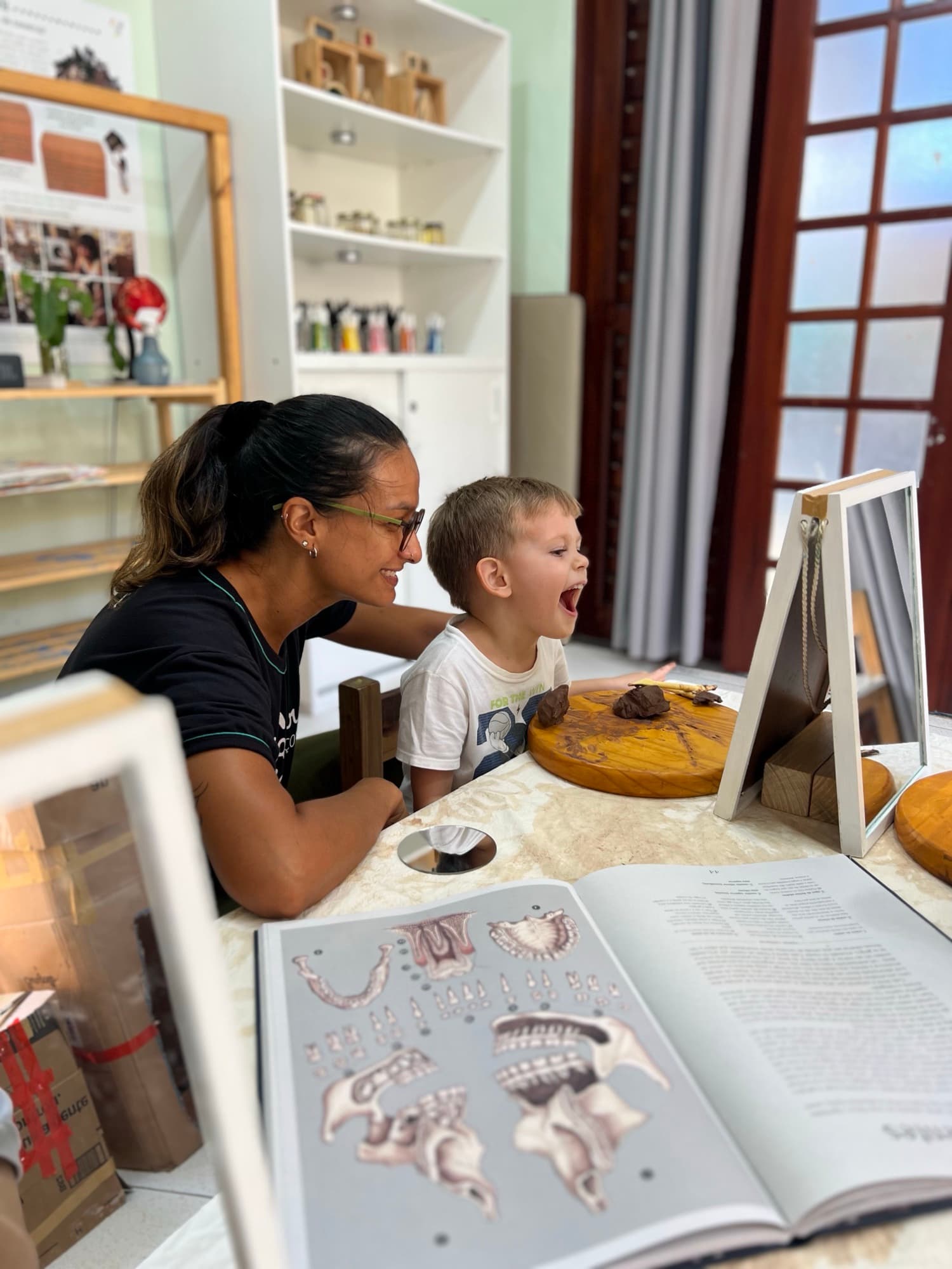 Educadora e menino descobrindo um livro de arte juntos